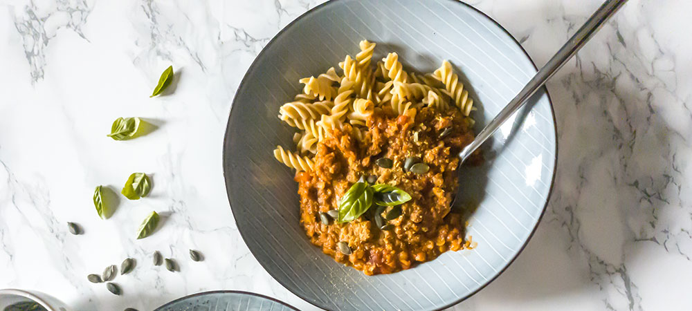 En tallerken med pastaskruer og vegansk kødsovs på toppen